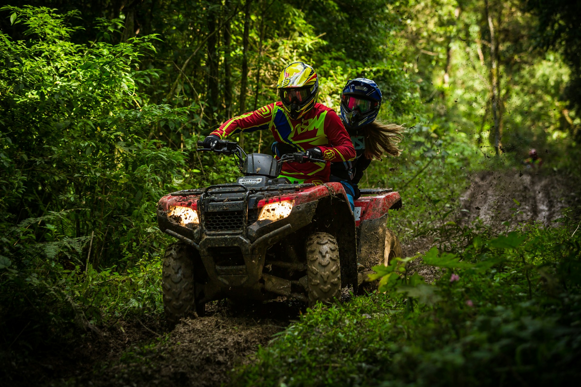 man riding atv on a forest trail