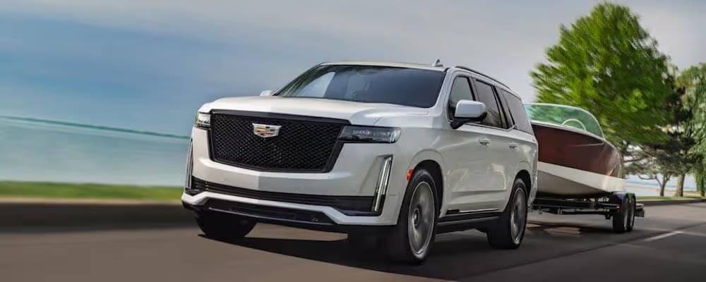 white cadillac escalade towing a boat